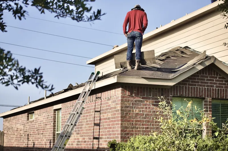 Professional roofer working on a residential roof in Aventura